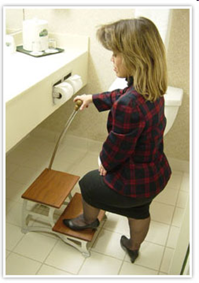 A little person demonstrating a stepping stool to access a hotel sink